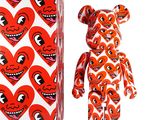 un ours en peluche rouge et blanc et une boîte en forme de cœur rouge et blanche