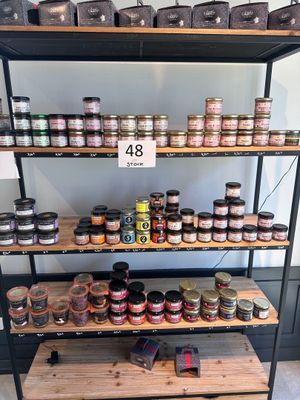 de nombreux bocaux de conserves sur les rayons du magasin