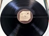 a black record on a white surface with a label on it