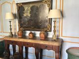 un tableau accroché au mur au-dessus d'une table dans une pièce