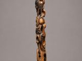 a wooden sculpture of a man holding a child on his back
