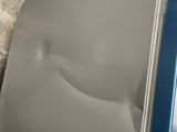a silver refrigerator sitting next to a brick wall