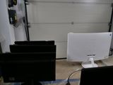 two computer monitors sitting on a desk in front of a garage door