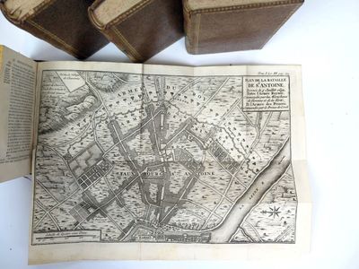 an old map on a table next to some old books