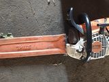 a chainsaw sitting on the ground next to a pair of scissors