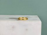 une bague en or posée sur un bloc de marbre