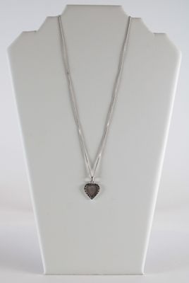 collier en argent avec un pendentif en forme de cœur sur un mannequin blanc