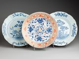 three blue and white plates with floral designs on them sitting on a stand