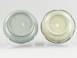 pair of green and white plates on stand against a white background