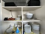 many plates and bowls on the shelves in the kitchen