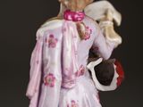 a figurine of a woman holding a dog and a cat