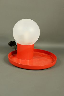 une mangeoire à oiseaux orange surmontée d'une lumière blanche