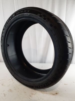 a close up of a tire on a white surface with a white curtain in the background