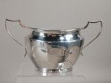 a silver vase on a clear pedestal with a white background