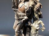 une statue représentant un homme tenant un couteau et un oiseau