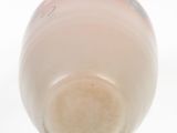 underside view of a bottle of milk on a white surface