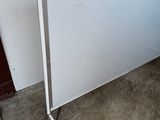 a white board on the floor next to a red door