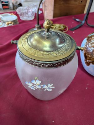 a glass jar with a lid on a table with a plate of food