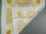 an image of a white and gold handkerchief with a picture of a man