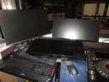 a laptop computer sitting on top of a desk next to two monitors