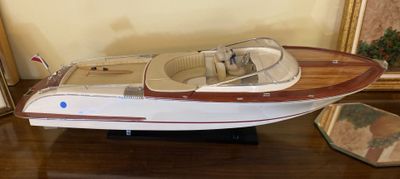 a model of a boat on a table next to a picture frame