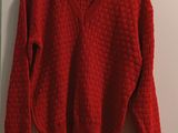 the sweater is hanging on a hanger on the wall