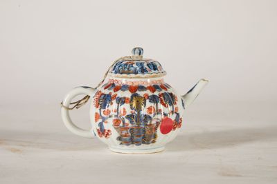 a small teapot with a handle on a table