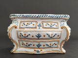 a white vase with blue and yellow designs on it