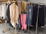 beaucoup de vêtements suspendus à une étagère dans une pièce