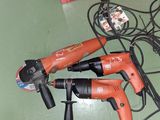 deux outils électriques posés par terre à côté d'une boîte rouge