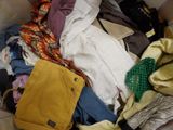 a box full of clothes and a purse on the floor