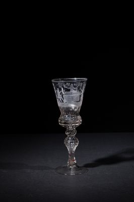 a wine glass sitting on a table with a black background