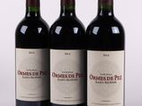 trois bouteilles de vin rouge posées côte à côte sur une table