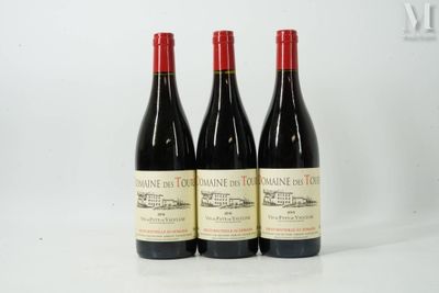 trois bouteilles de vin rouge posées côte à côte sur une table
