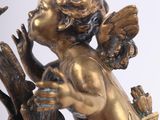 a statue of an angel holding a bird on a branch