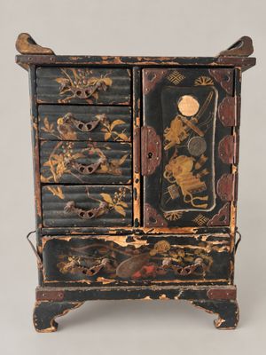 a black and gold chest of drawers with a clock on top