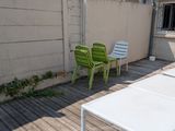 trois chaises vertes et blanches posées sur une terrasse en bois