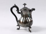 a silver coffee pot on a stand on a white background