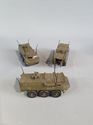 three toy army vehicles sitting on top of a white surface