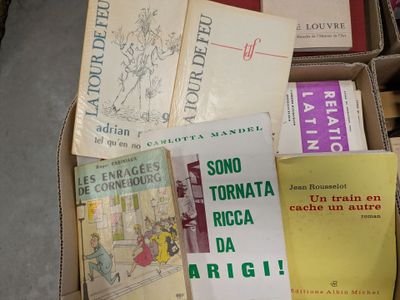 many books in a box that are sitting on the floor