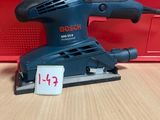 un gros plan d'une ponceuse posée sur une table, avec une étiquette de prix