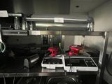 plan de travail en acier inoxydable dans une cuisine professionnelle équipée de nombreux appareils électroménagers