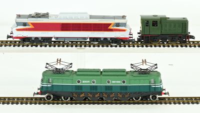 Il y a deux trains sur les voies : l'un est vert et l'autre est rouge.