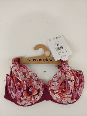 un gros plan d'une bralette suspendue à un cintre sur un fond blanc