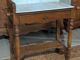 une table en bois avec un plateau en marbre dans une pièce