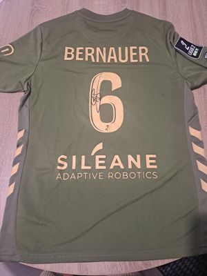 La chemise posée sur la table est verte et porte le numéro 6.