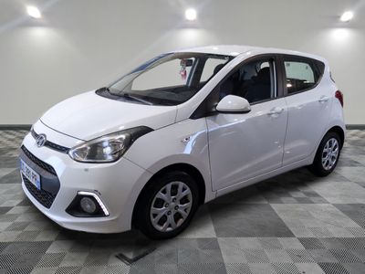 la voiture blanche est garée sur le sol à carreaux d'un garage