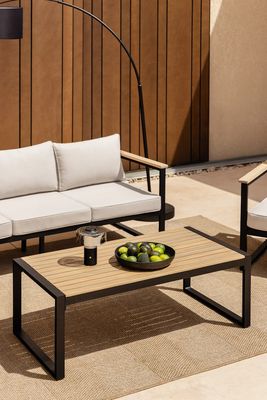 une photo d'une terrasse avec un canapé, une table et une lampe