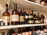 many bottles on the shelves of a store with soaps and lotions