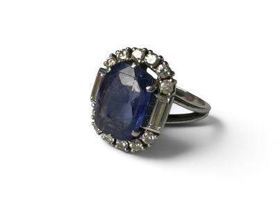 gros plan d'une bague avec une pierre bleue entourée de diamants